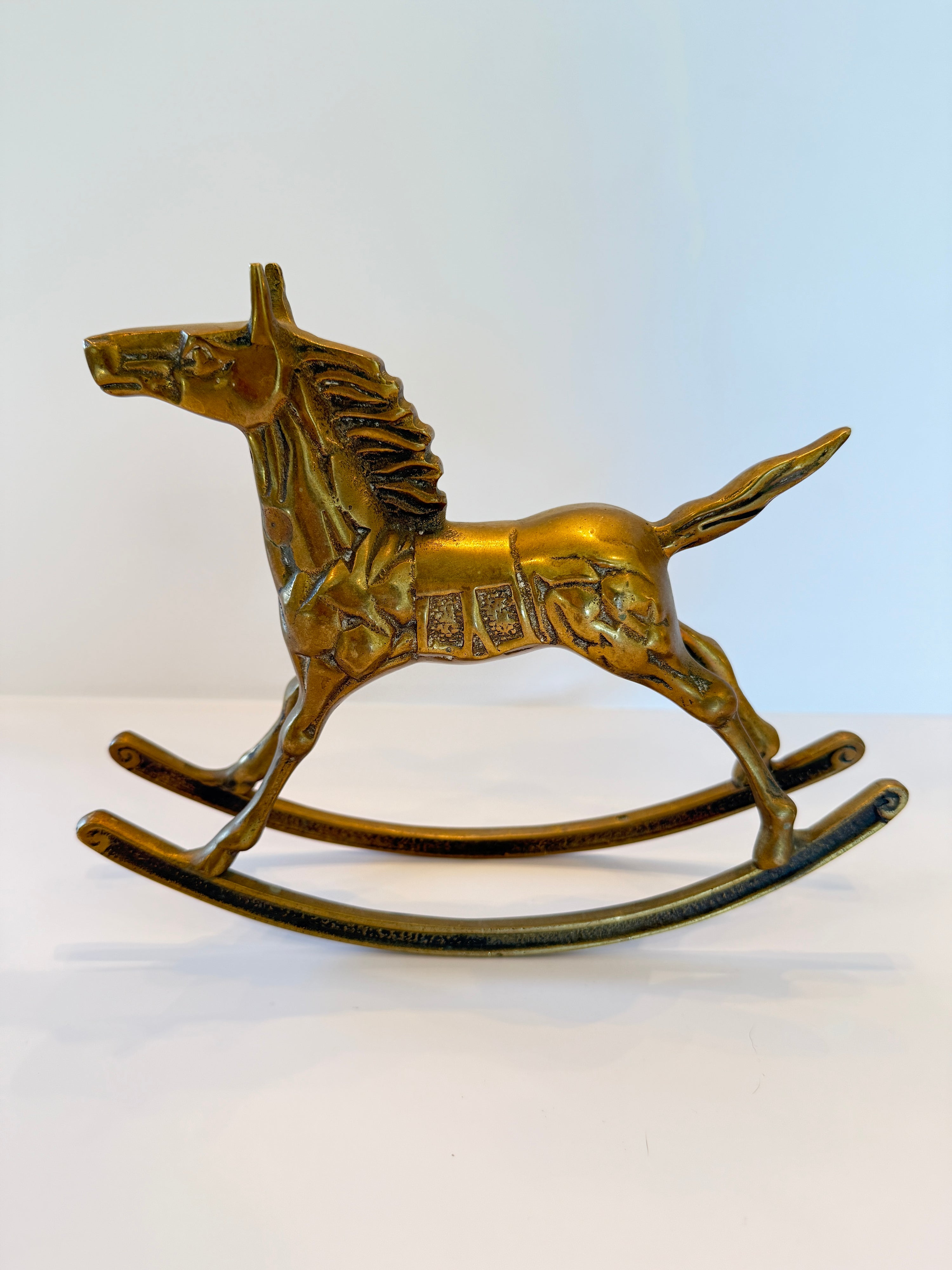 Solid brass rocking horse sculpture with a warm patina, 6.5 inches