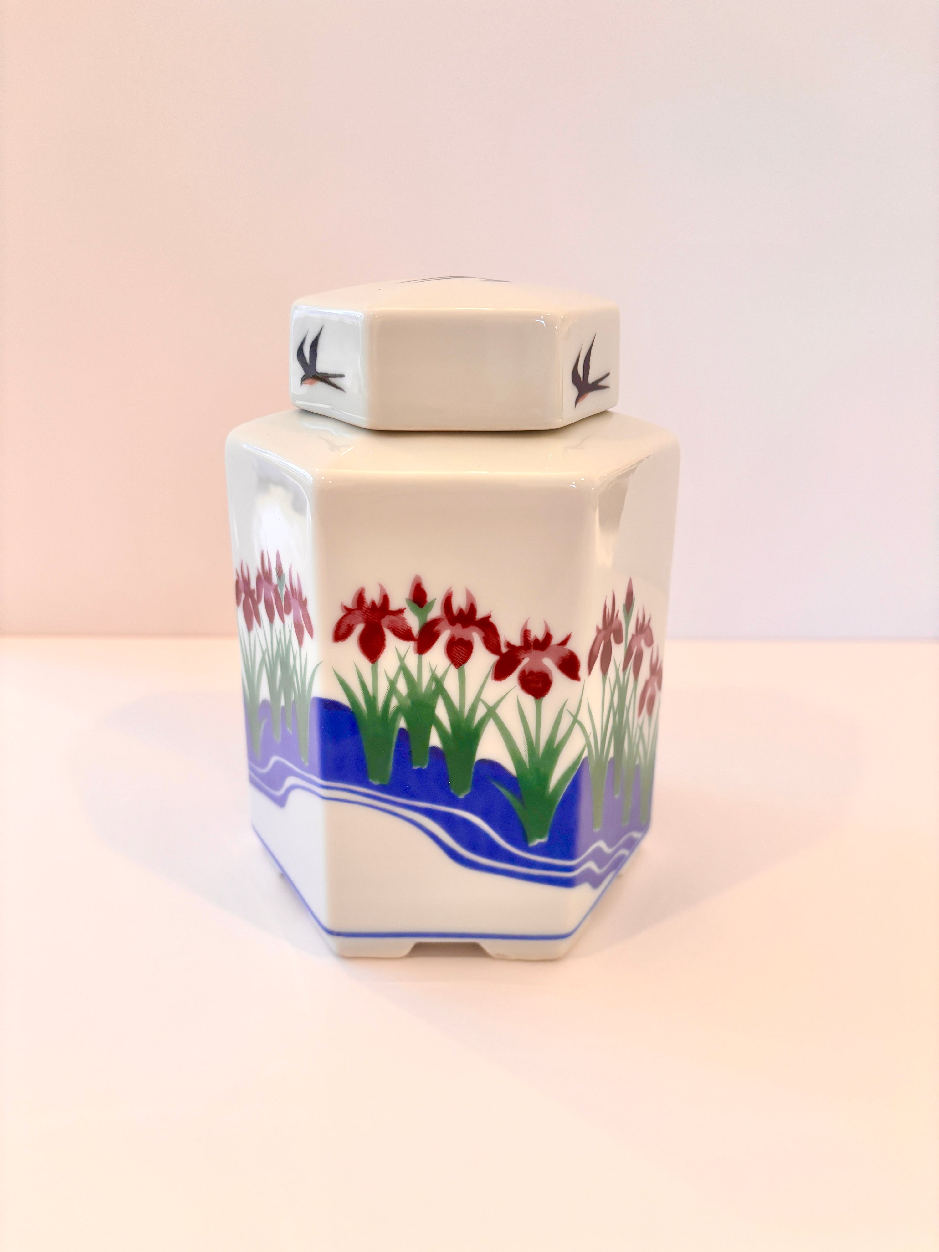 Pair of Jennifer Wong hexagon porcelain ginger jars with purple irises and a black swallow on each lid