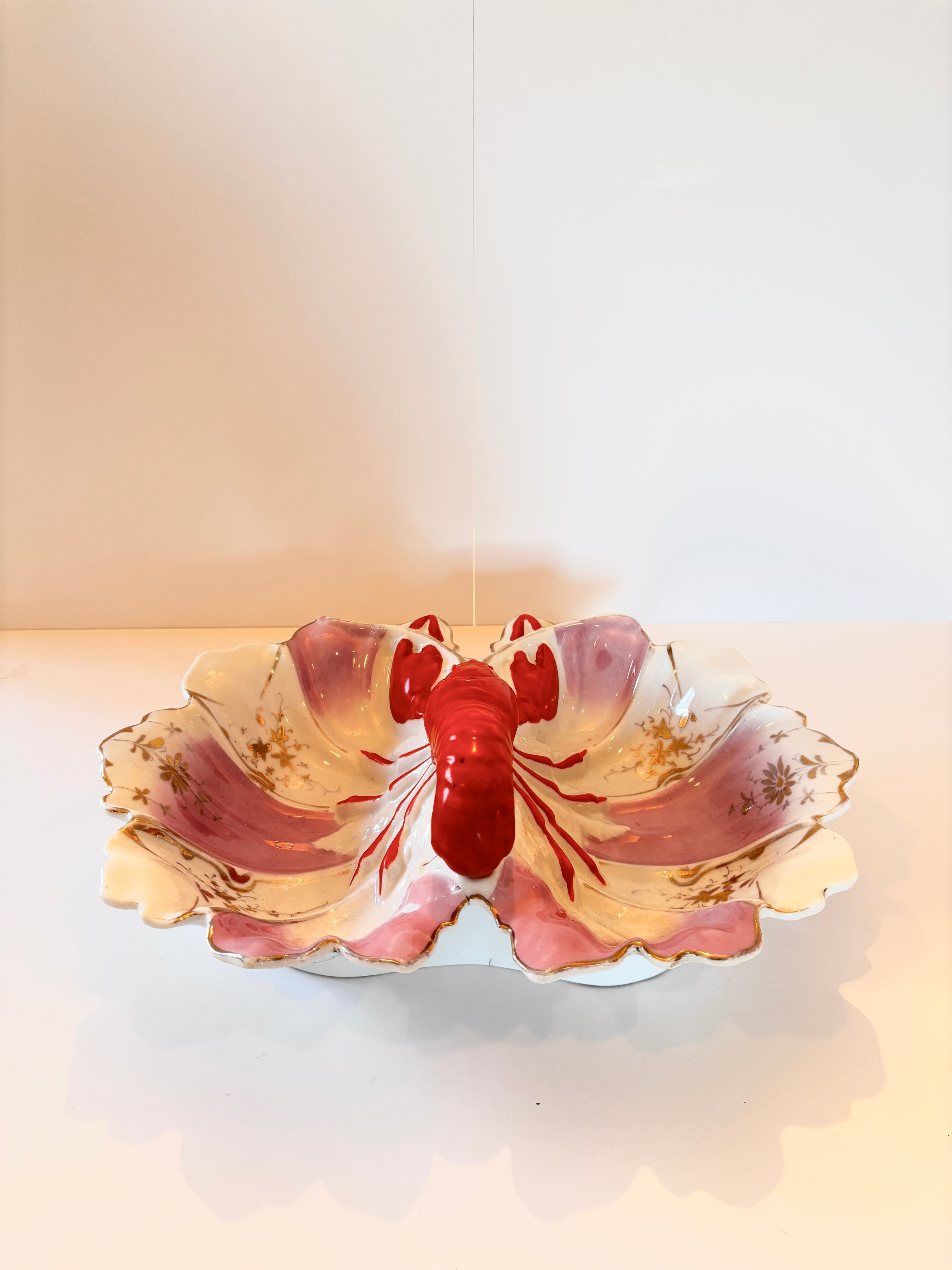 Vintage porcelain lobster dish with a sculpted red lobster and scalloped purple-and-gold border