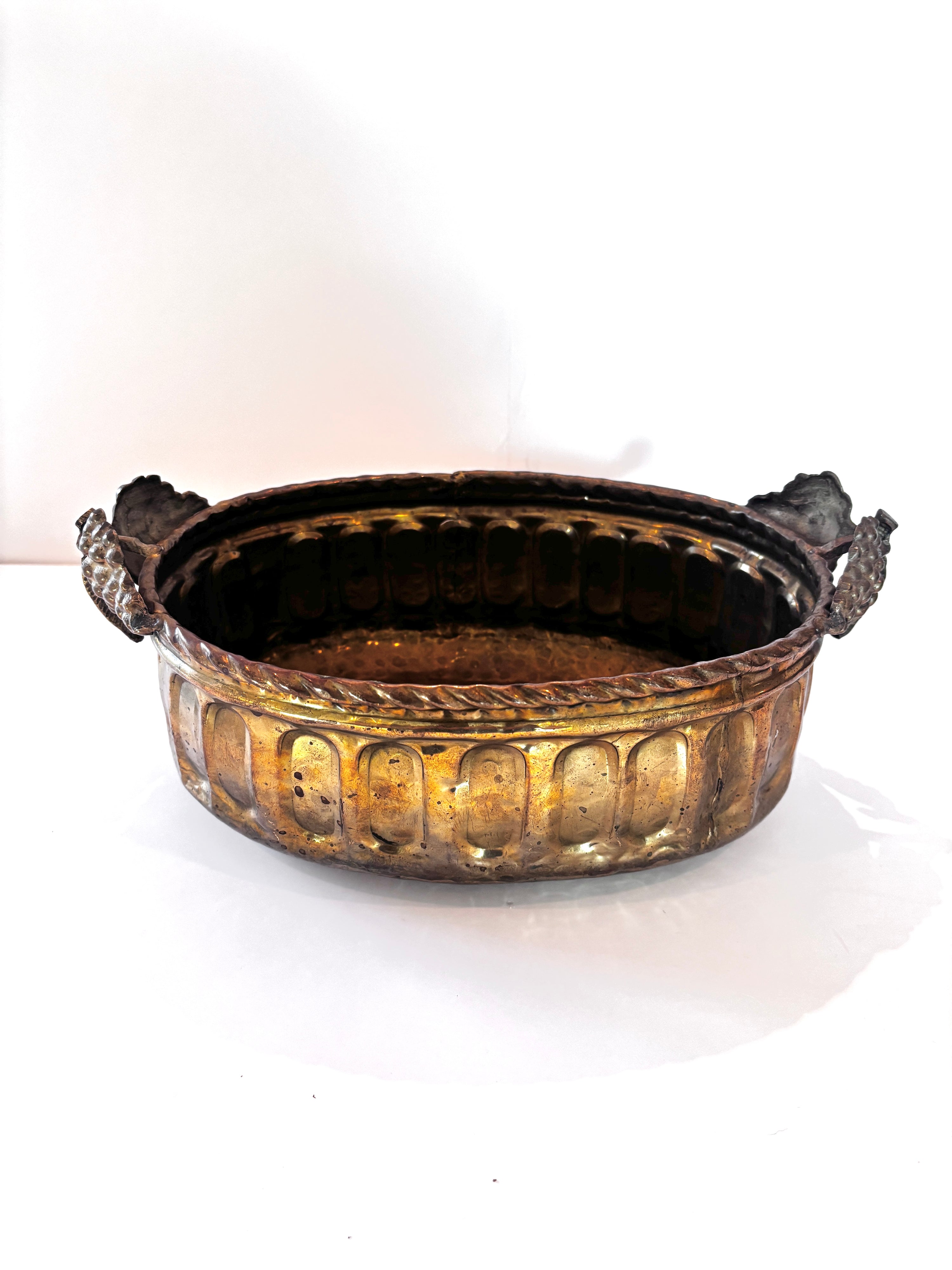 Vintage hammered brass bowl with scalloped edges and ornate handles