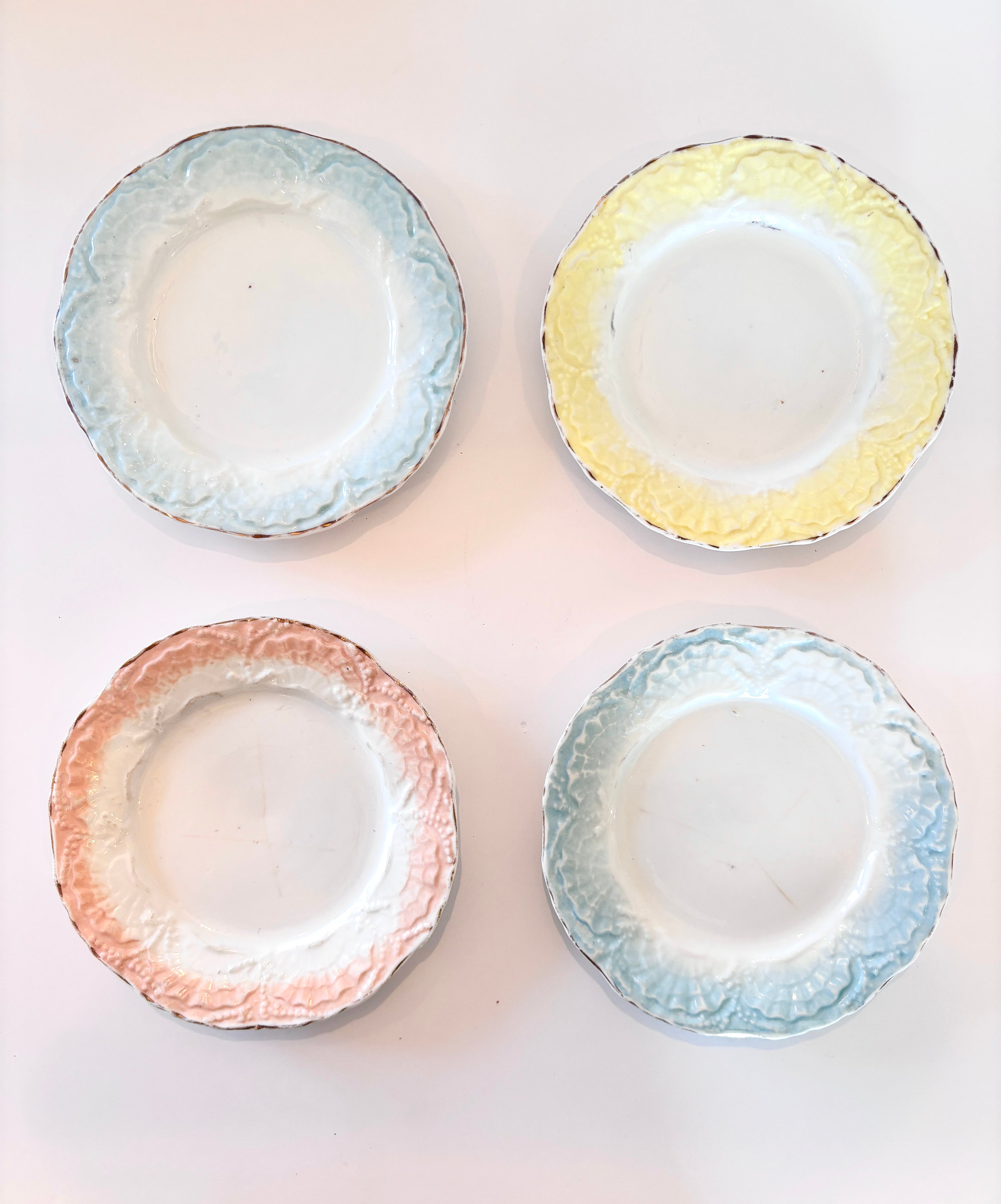 Set of four vintage seashell-shaped plates with scalloped pastel edges