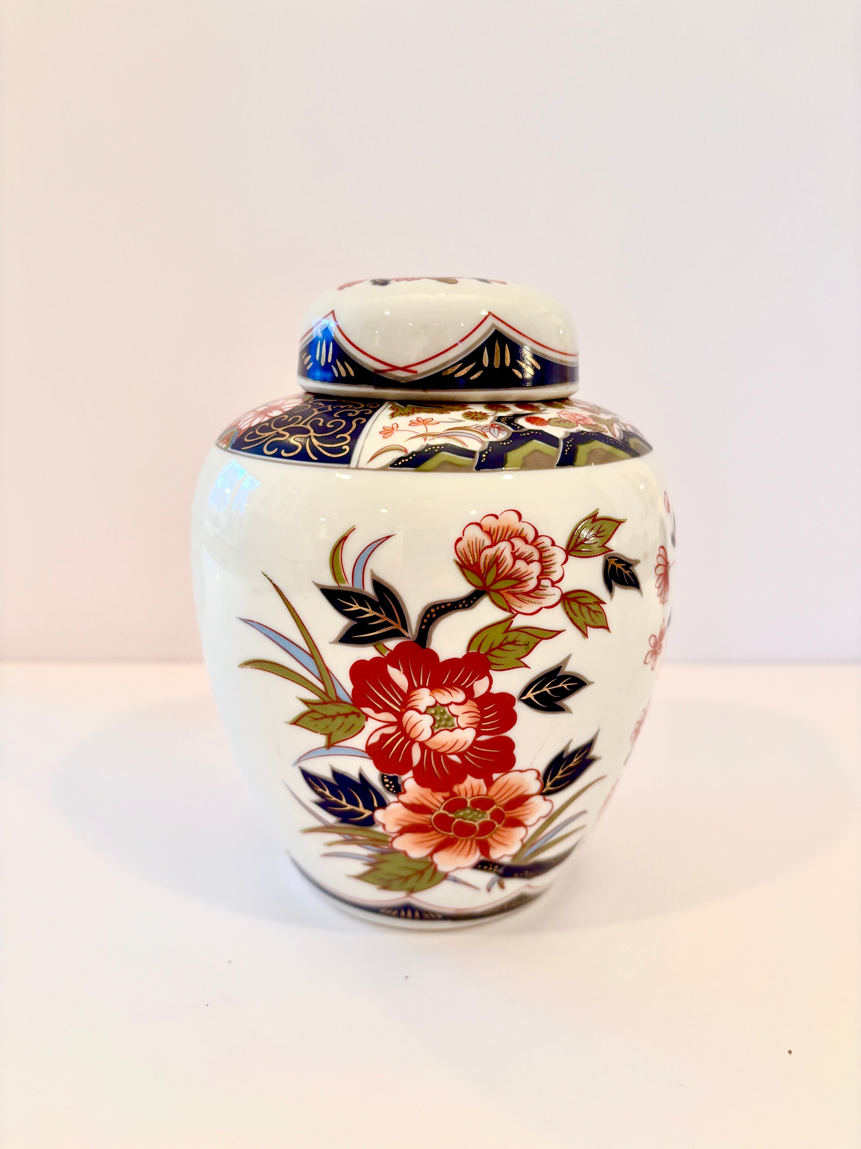 Vintage Imari porcelain ginger jar with matching lid in red, blue, green, and gold