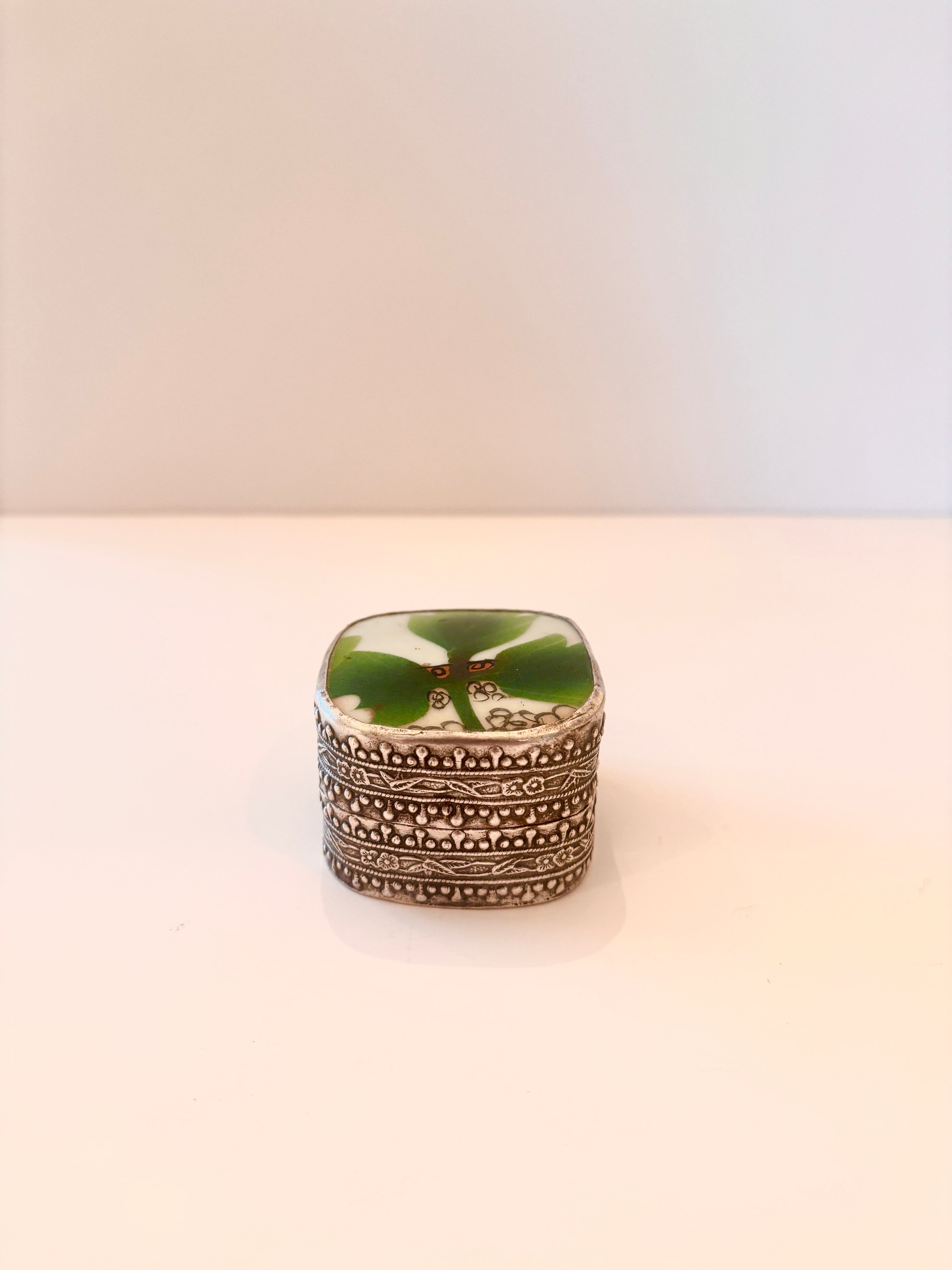 Small silver-plated box with a green enamel leaf on the lid
