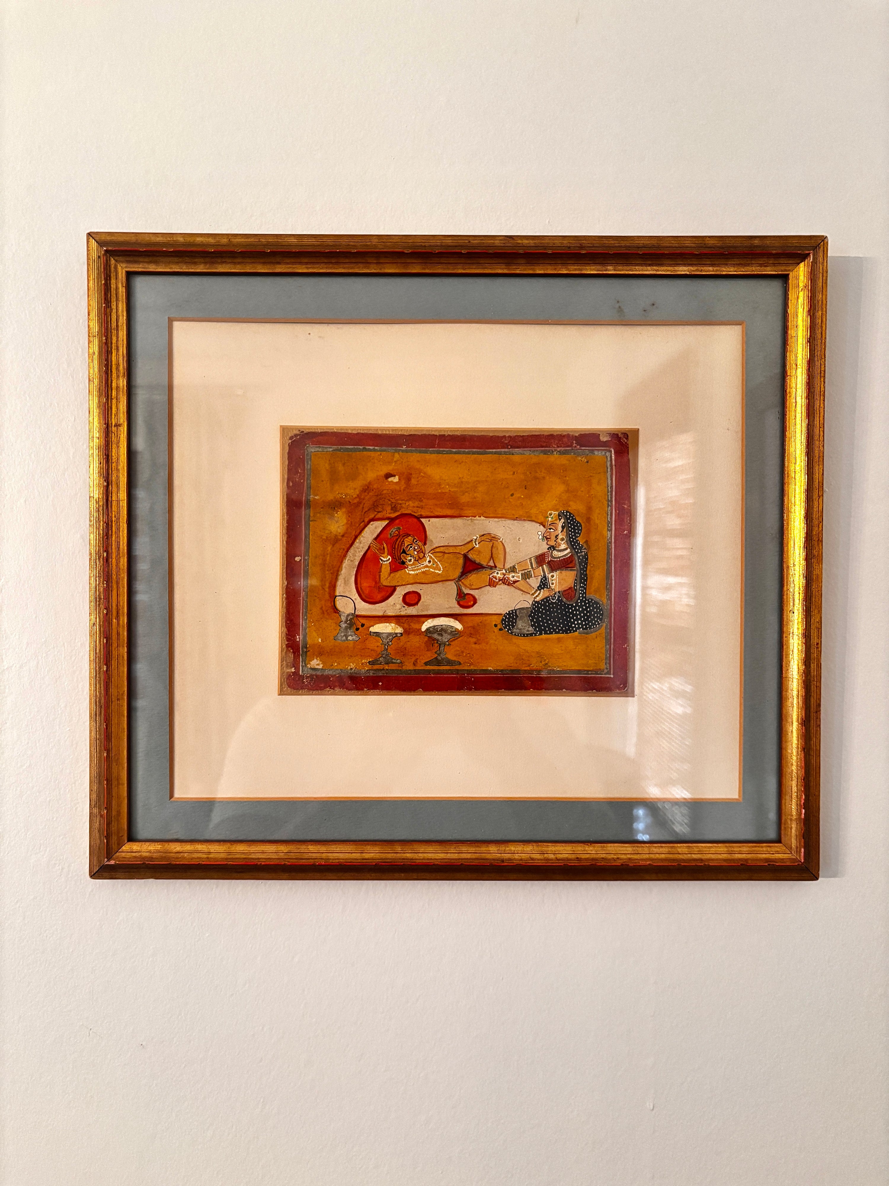 Vintage Mughal-style miniature painting with a richly colored scene in warm tones