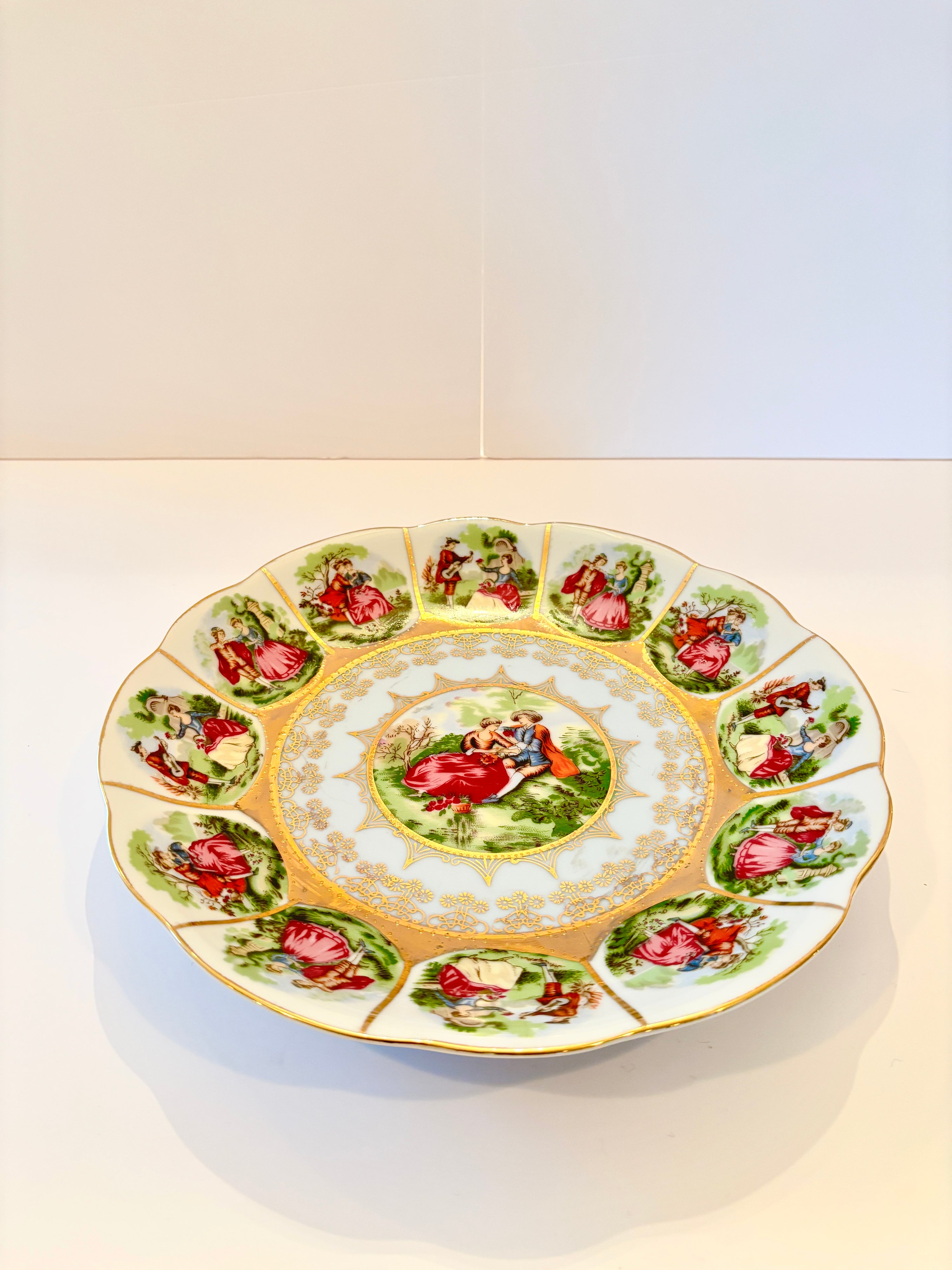 Vintage Royal Vienna porcelain plate with a hand-painted pastoral scene and gold scalloped edge