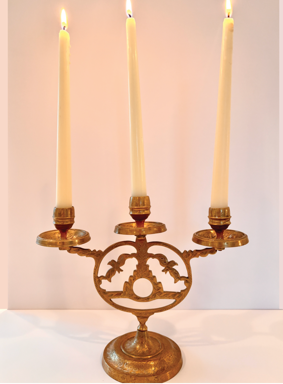 Vintage brass candelabra made in India with curved arms and floral engraving