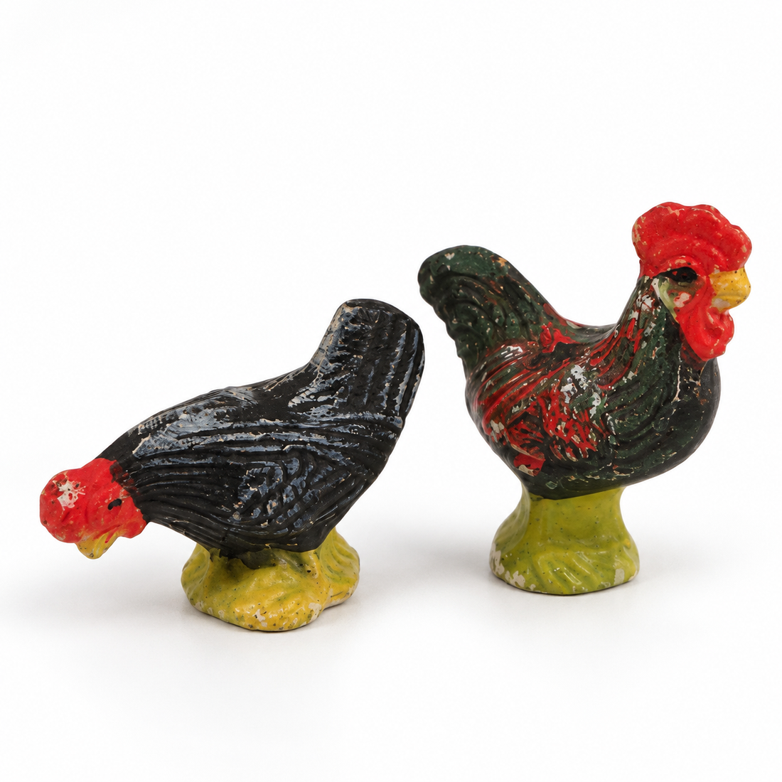 Pair of vintage hand-painted ceramic rooster and hen figurines on green bases, made in Japan, on a white background