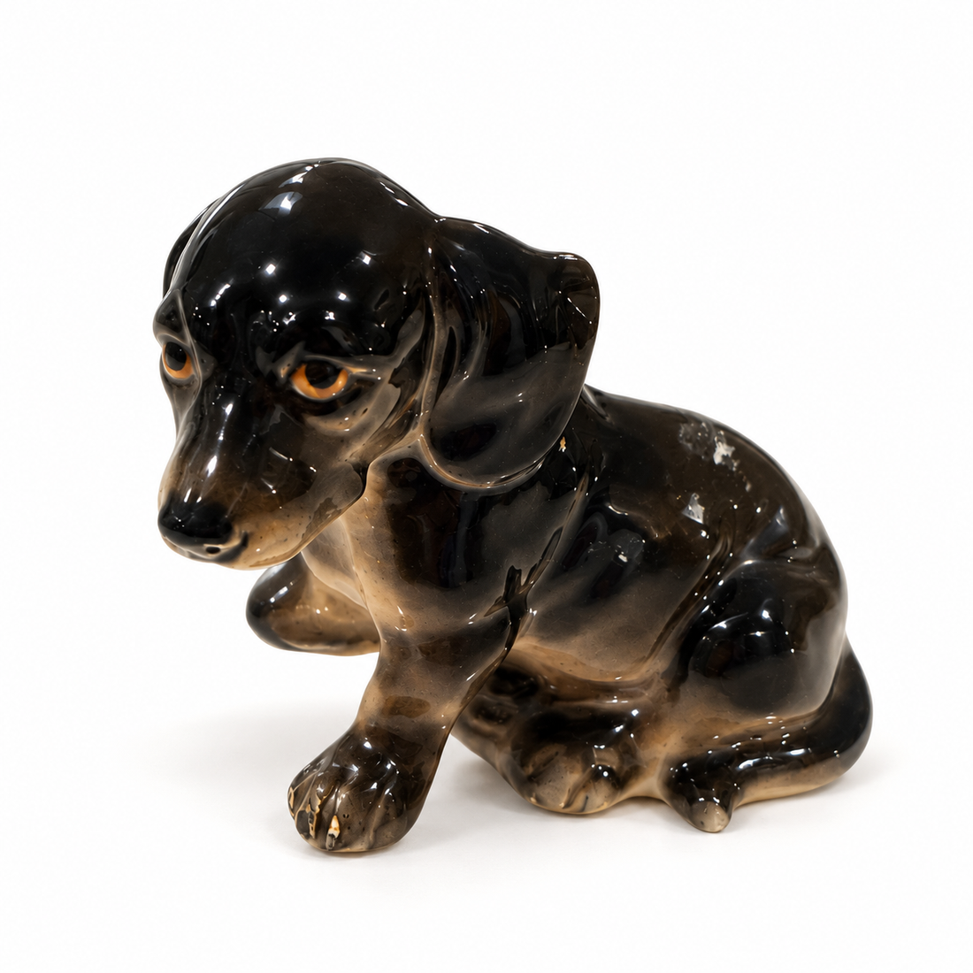 Vintage hand-painted black and tan dachshund puppy figurine, made in Japan, on white background