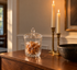 St. George Crystal Odyssey cut lead crystal covered jar filled with butterscotch candies on a walnut dining room sideboard beside brass candlesticks