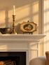 Patti McCarthy oil of a retriever on a cushion, on a small shaped Florentine board set on a mini easel on a white mantel beside a brass candlestick