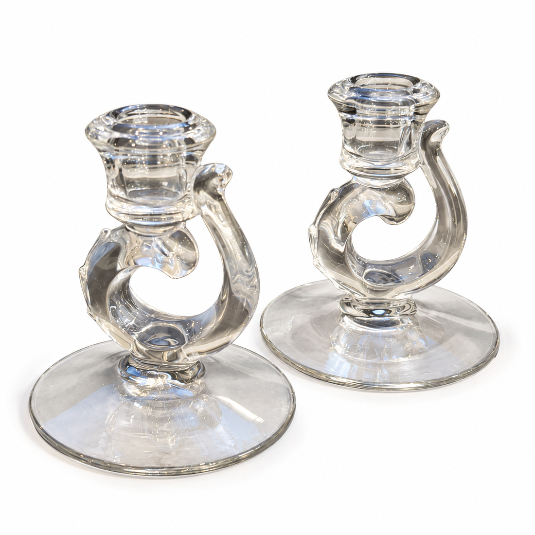 Fostoria clear glass scroll candleholders, angled view on white