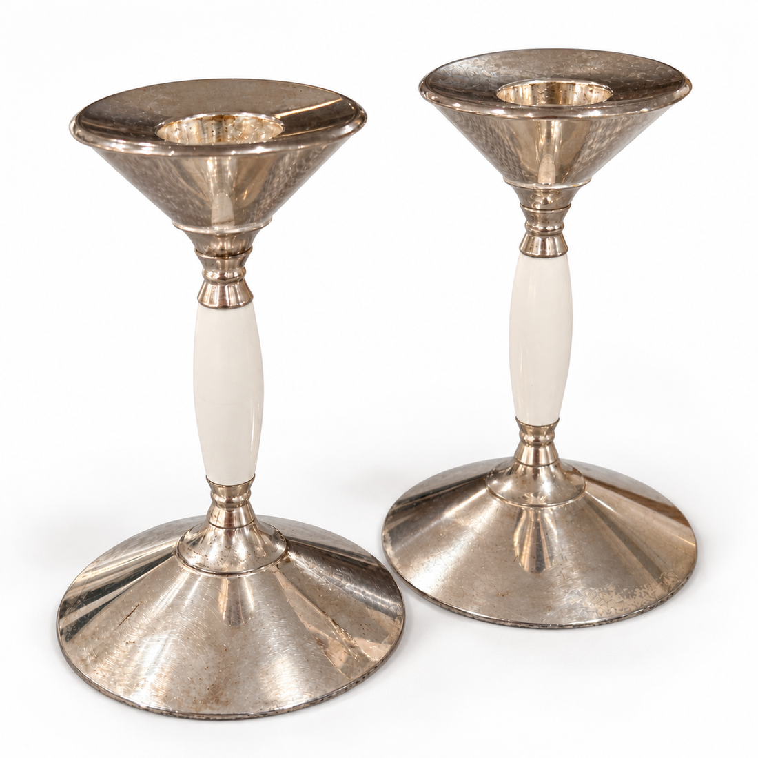 Silver plated candleholders with white stems, angled view on white