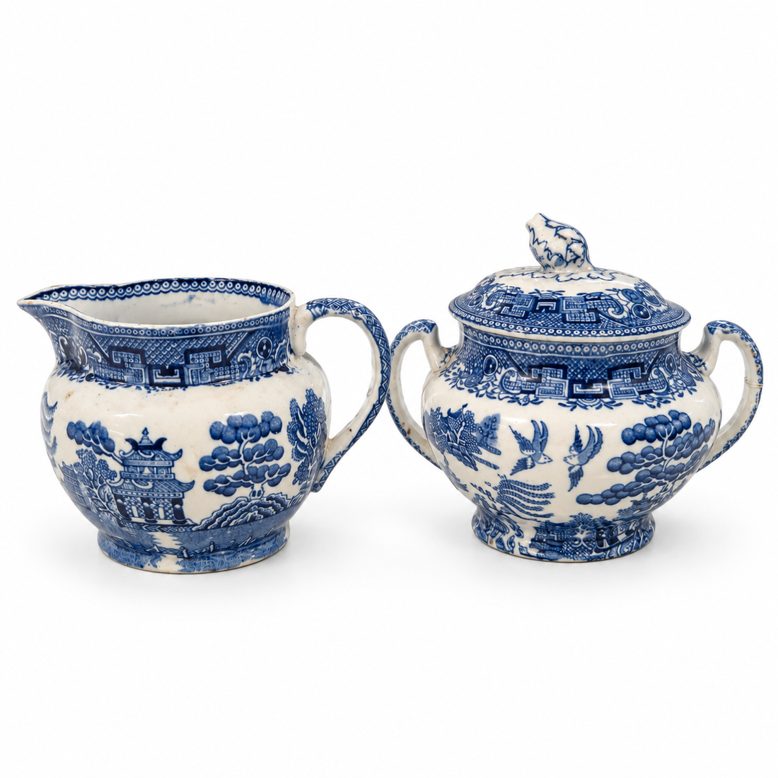 Blue Willow creamer and covered sugar bowl, angled view on white